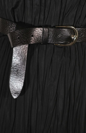 Close-up of a black dress with a metallic belt buckle.